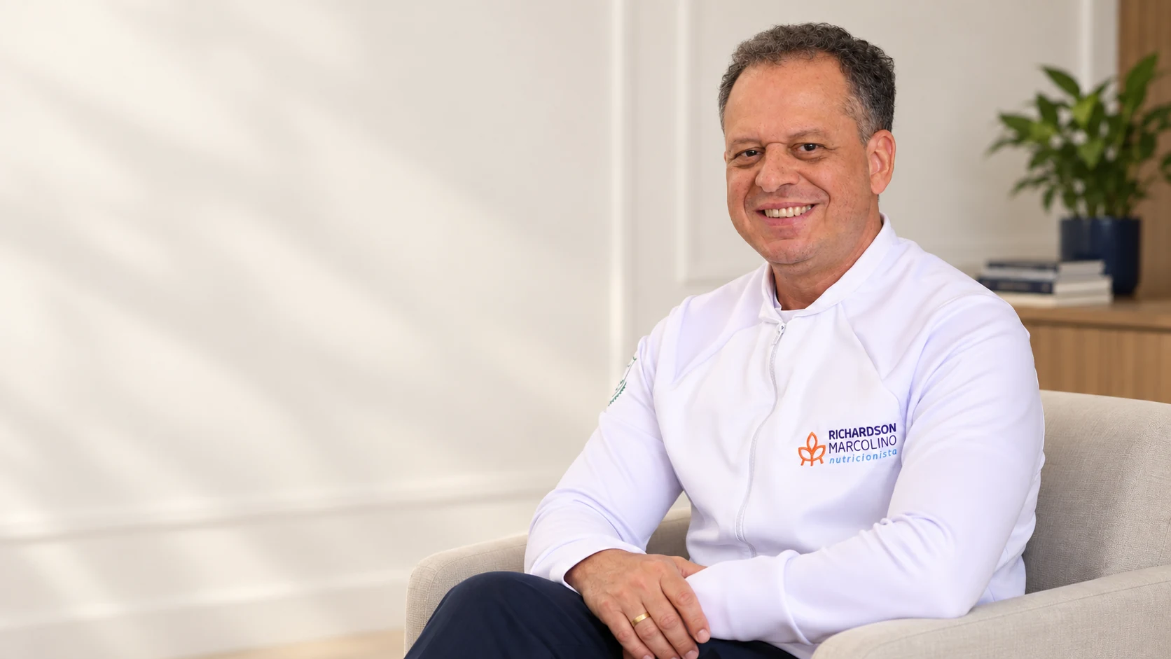 Richardson Marcolino sorrindo em uma composição editorial inspirada em seu ambiente de atendimento